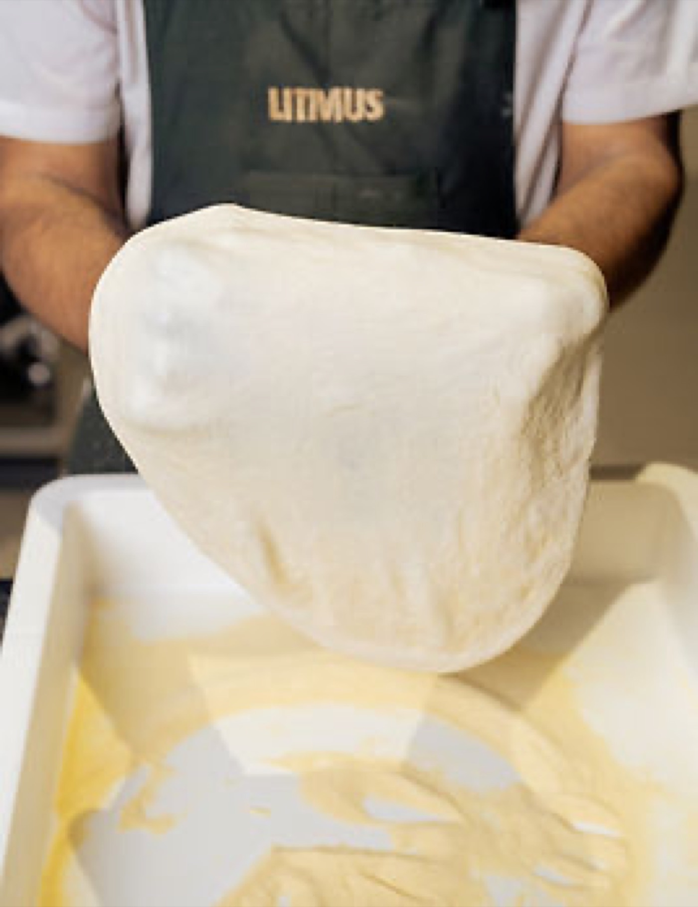 Hands stretching sourdough at Litmus Brasserie